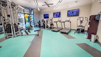 Gym with cardio machines and weights at Civic at Frisco Square Apartments, Frisco, TX, Texas