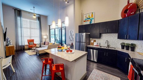 Kitchen with a white countertop and black cabinets at Civic at Frisco Square Apartments, Texas