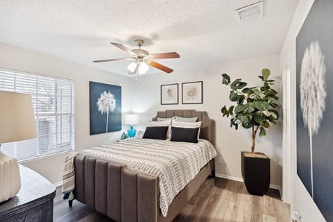 Bedroom with upholstered bed and ceiling fan at Altamonte Apartments, San Antonio, TX 78216