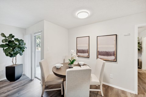 Dining area with round table and modern artwork at Altamonte Apartments, Texas