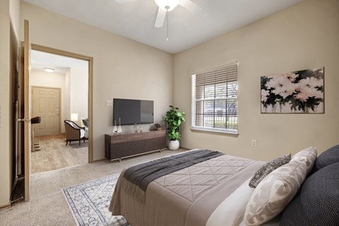 A bedroom with a large bed and a flat screen TV.