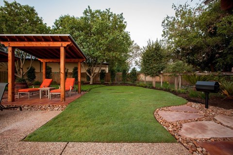 A backyard with a gazebo and a mailbox.