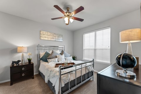 Bedroom with metal bed frame and ceiling fan at Gateway Cedars Apartments, Forney, TX