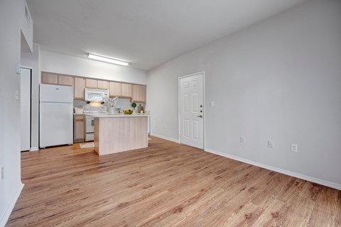 A kitchen with white appliances and wooden floors.
