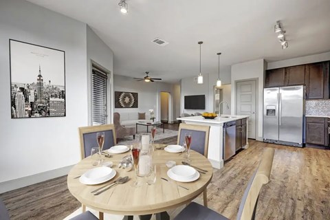A dining room with a wooden table set for two.