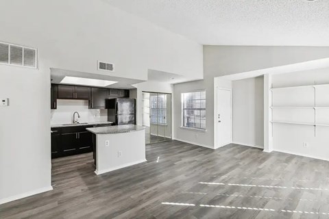 A kitchen with white cabinets and a black countertop.