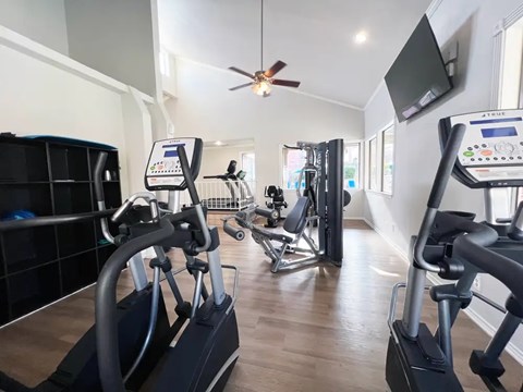 A gym with treadmills and elliptical machines.