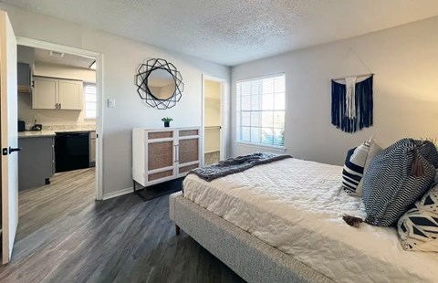 A bedroom with a bed, a window, and a mirror.