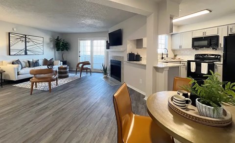 A modern living room with a fireplace and a dining table set for two.