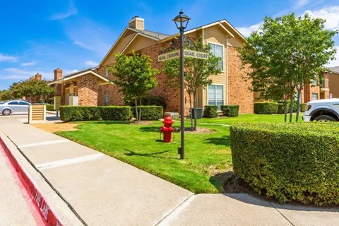 A residential building with a red fire hydrant in front of it.