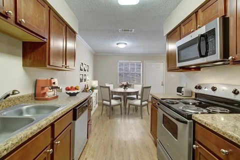 A kitchen with wooden cabinets and a stove top oven.