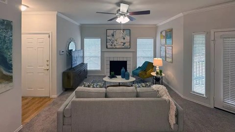 A living room with a grey couch and a fireplace.