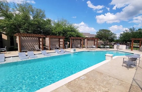 Resort style swimming pool with tanning ledge and cabanas at Arbors at Wolf Pen Creek Apartments, College Station