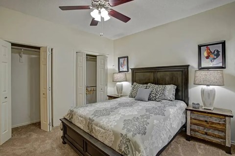 Bedroom with dark wood furniture and ceiling fan at Arbors at Wolf Pen Creek Apartments, College Station, 77840