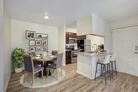 A kitchen with a dining table and chairs.