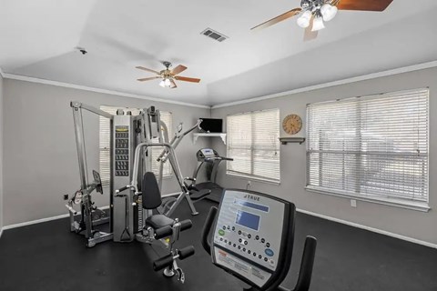 Fitness center with cardio and weight equipment at Encino Park Apartments, Texas, 76904