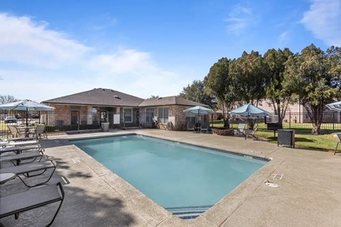 Resort style swimming pool with sundeck and lounge chairs at Encino Park Apartments, San Angelo, Texas