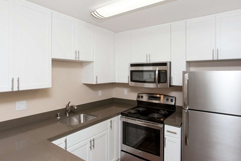 a kitchen with stainless steel appliances and white cabinets