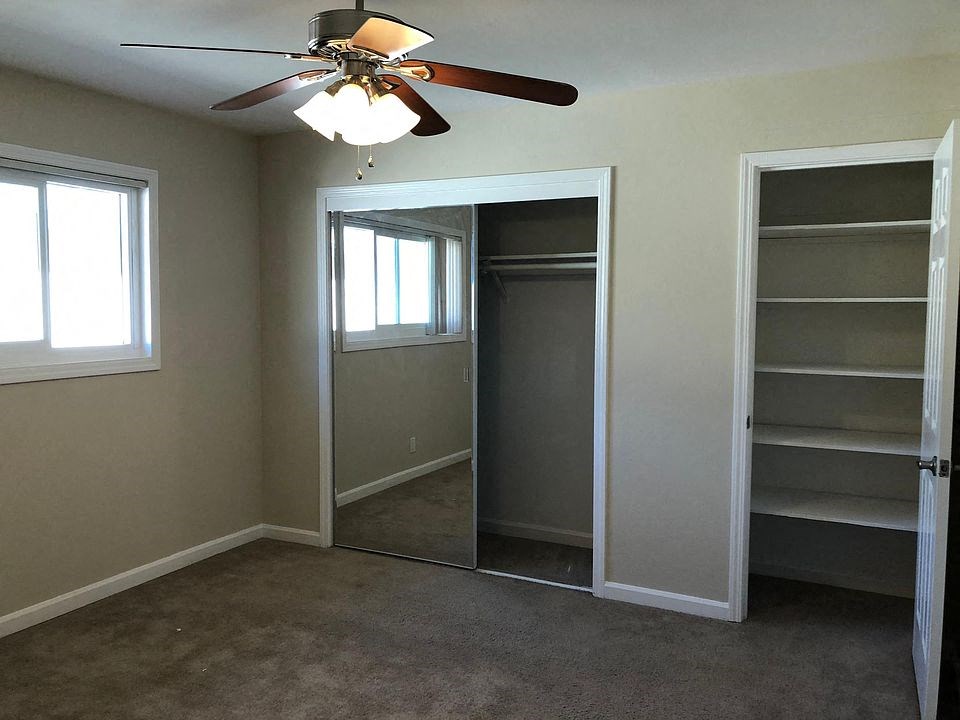 a bedroom with a closet and a ceiling fan