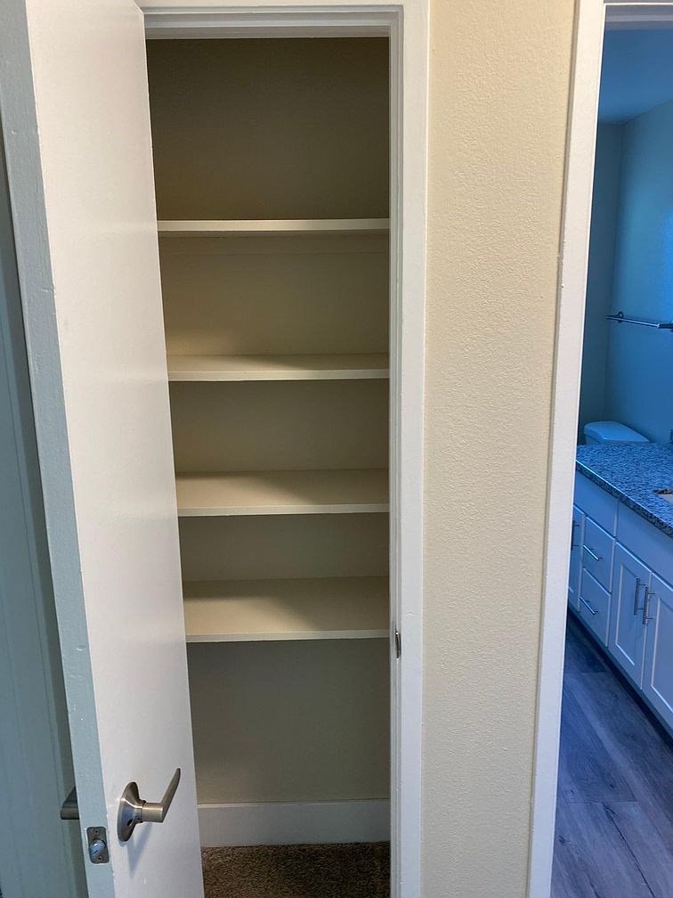 A white door with a silver handle is open.