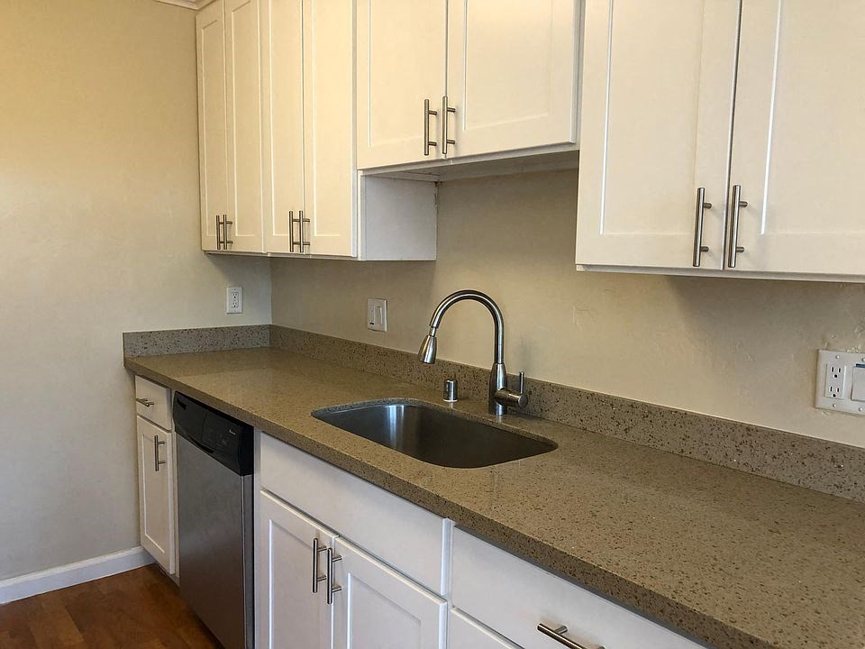 a kitchen with a sink and white cabinets