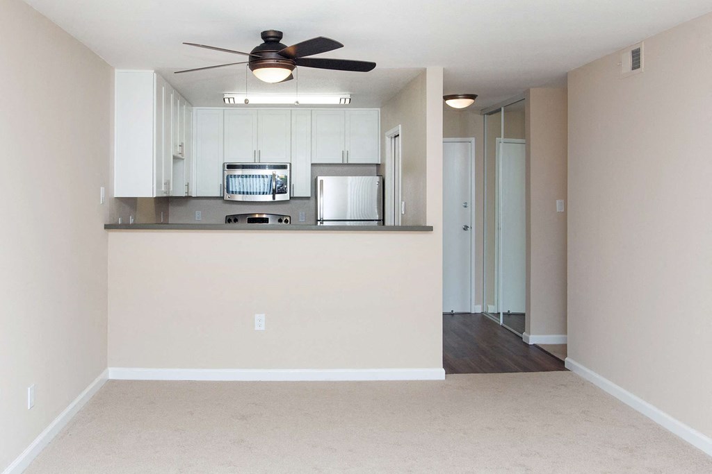 a bedroom with a large window and a ceiling fan