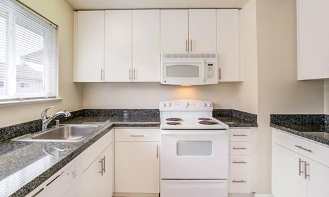 a kitchen with white appliances and white cabinets