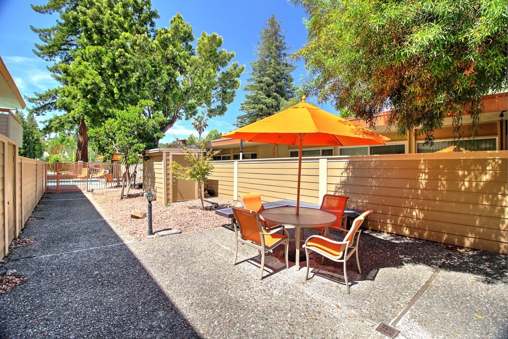 a patio with a table and chairs and an umbrella
