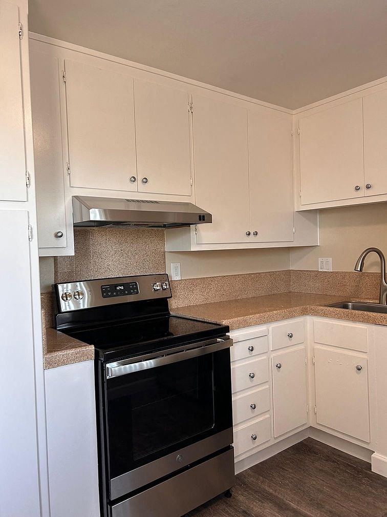 a kitchen with a stove and white cabinets
