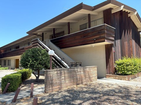 A modern house with a wooden exterior and a sign that reads "1707 ALLEN".