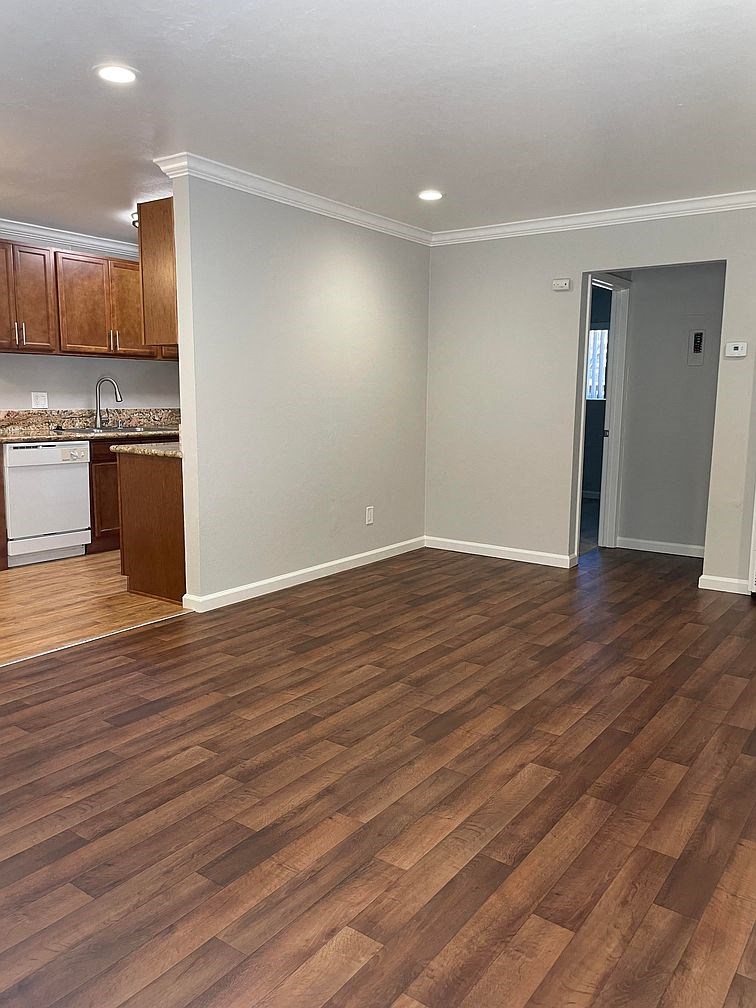 A kitchen with wooden floors and white walls.