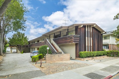 A modern house with a wooden exterior and a car parked in front.