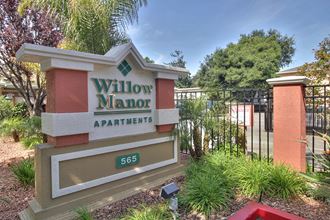 a sign for willow manor apartments in front of a gate