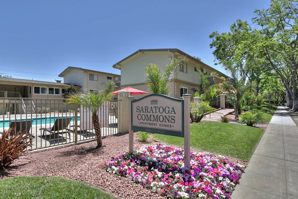 A sign for SARATOGA COMMONS in front of a pool.