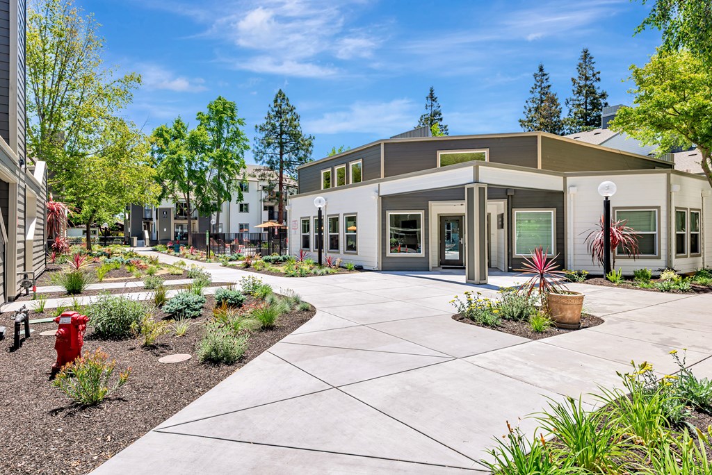 A building with a grey roof and a red fire hydrant in front of it.