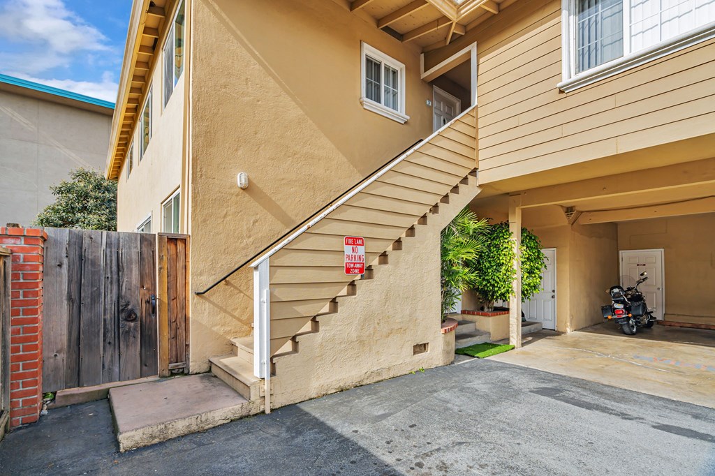 A tan building with a staircase leading to the second floor.