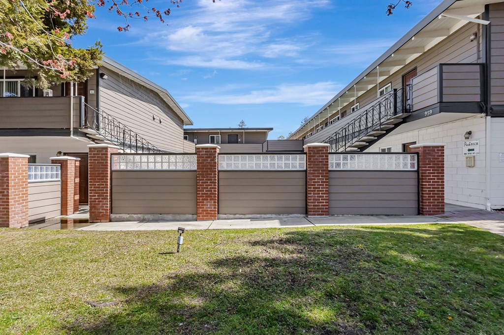 A row of houses with garages and a small sign in the front yard.