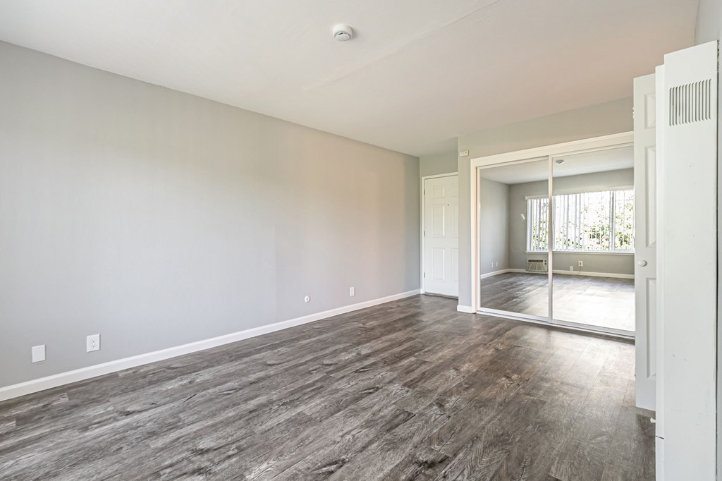 A room with a sliding glass door leading to a balcony.