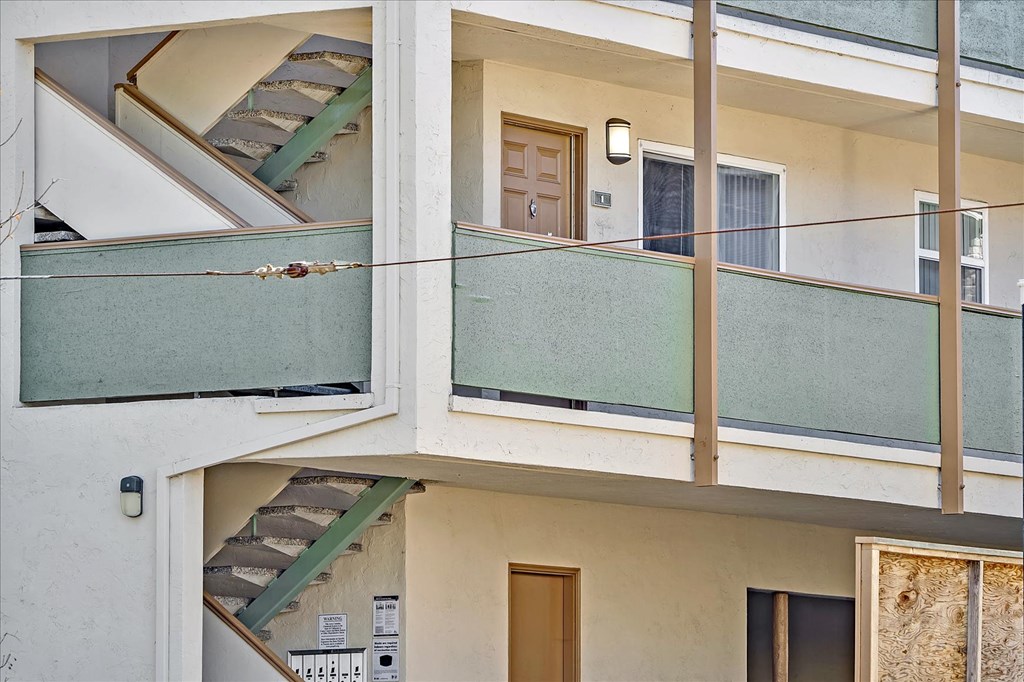 a balcony of a building with stairs and a glass door