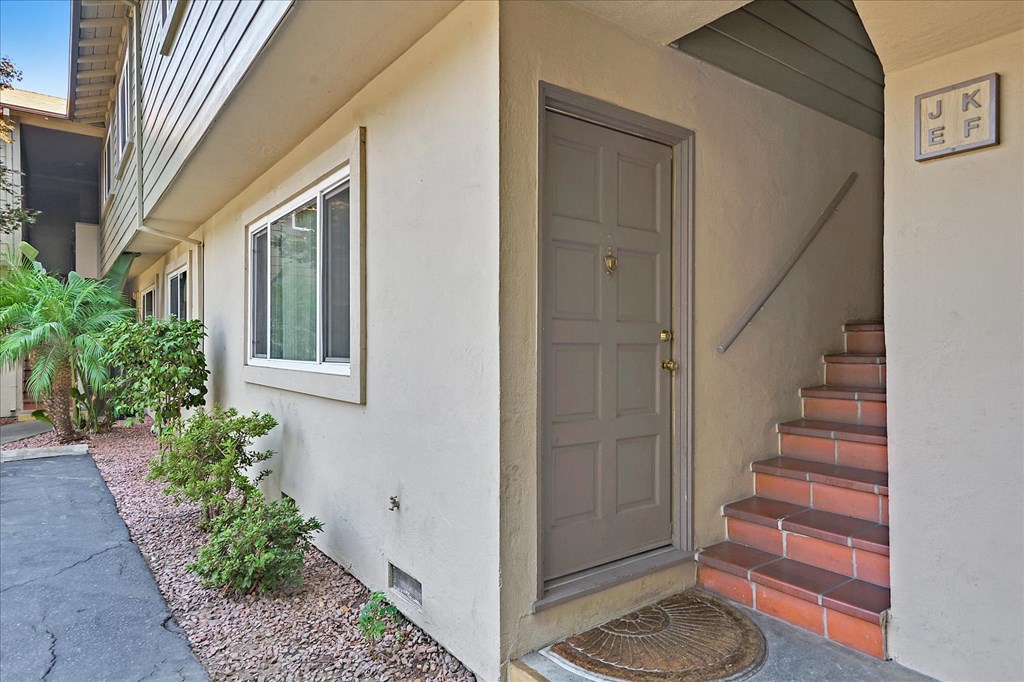 A house with a grey door and a staircase leading to the entrance.