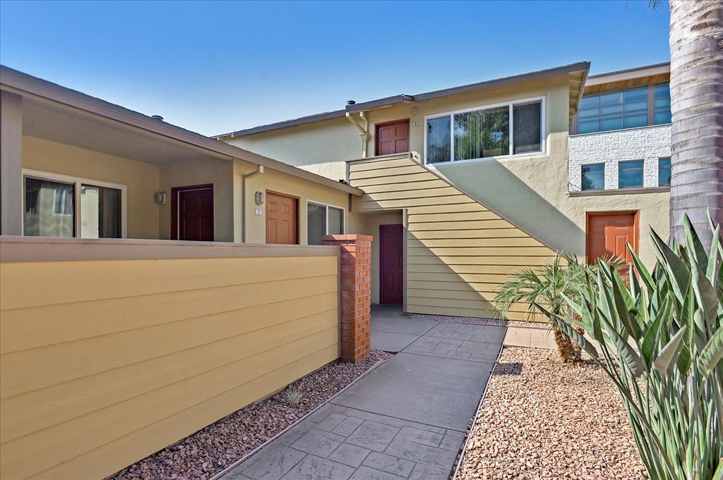 the front of a house with a staircase and a driveway