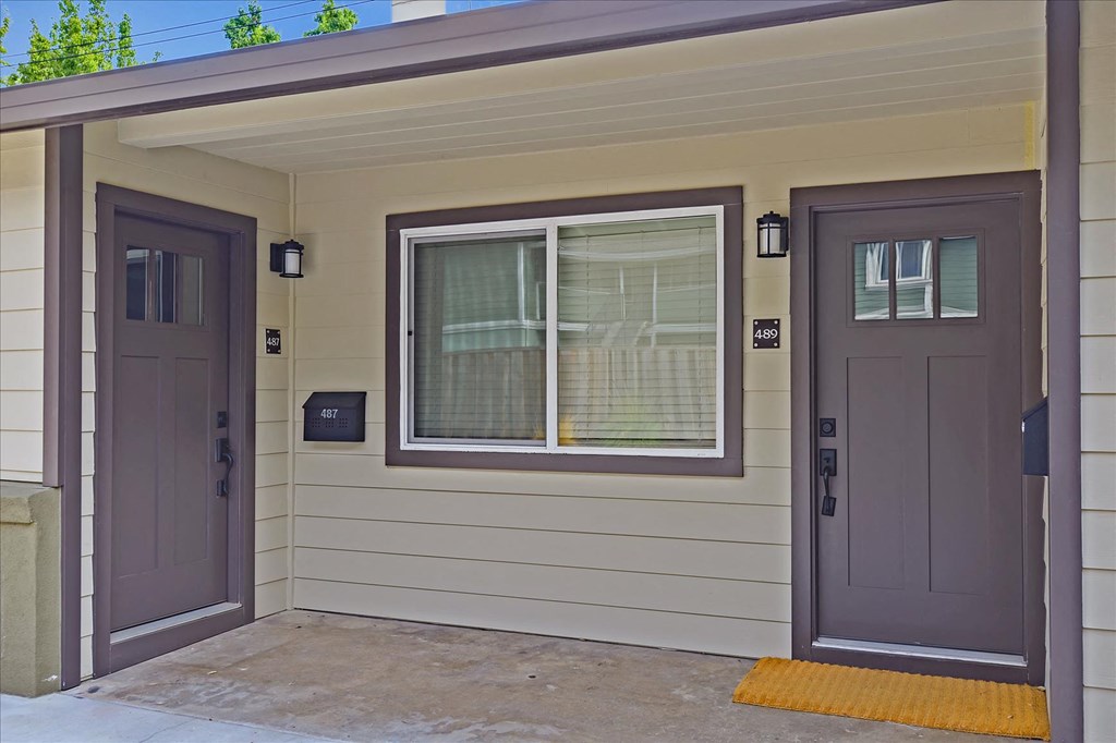 the front of a house with two doors and a window