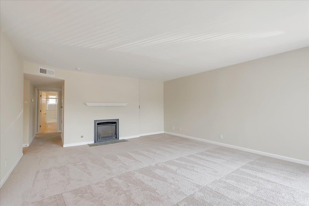 a empty living room with a fireplace