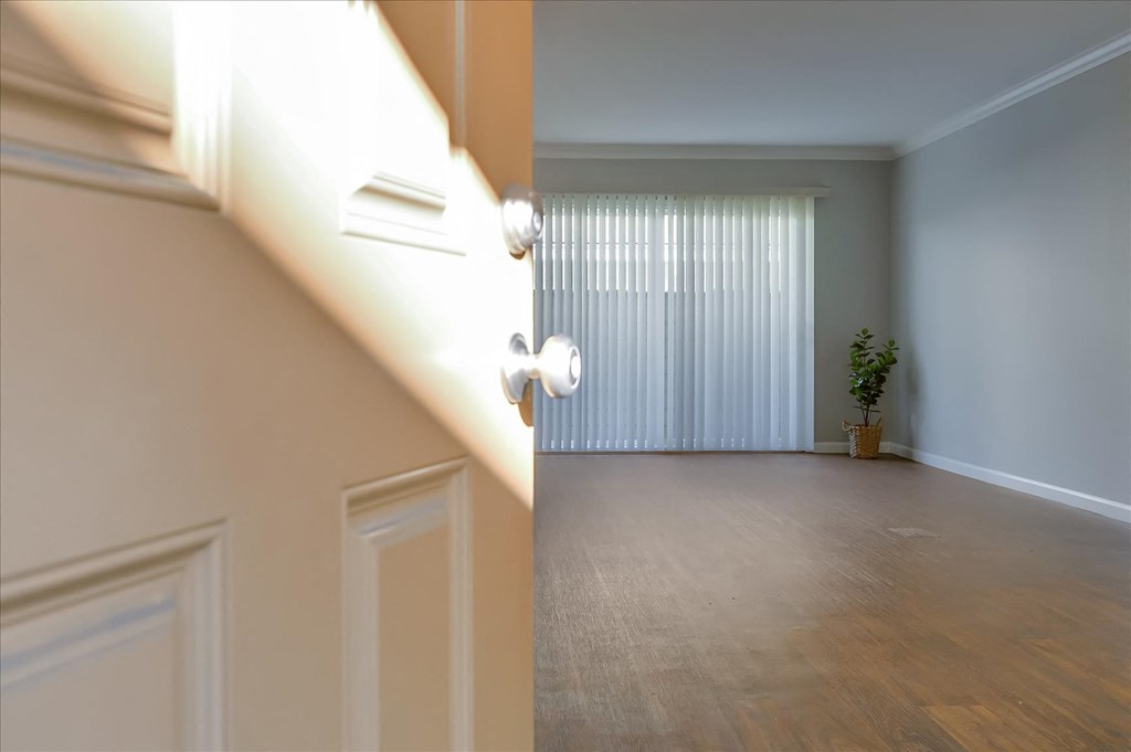 an empty living room with a sliding glass door and a window