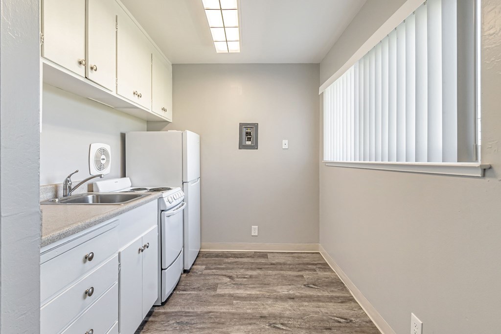 A kitchen with white cabinets and a washer and dryer.