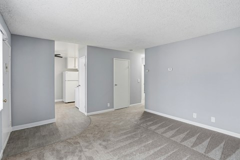A spacious room with a carpeted floor and a few doors.