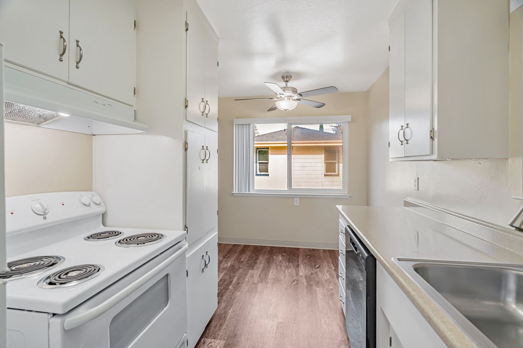 A kitchen with white appliances and cabinets.
