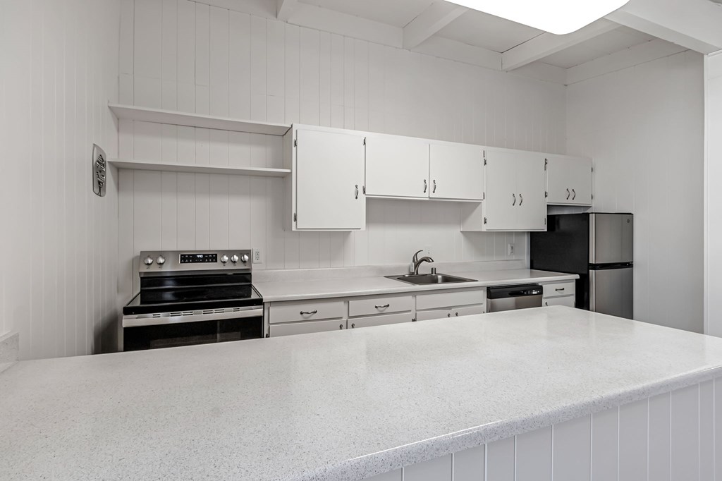 A kitchen with white cabinets and appliances.