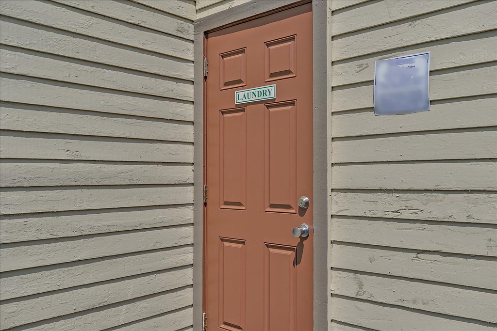 A brown door with a silver handle and a sign above it that says
