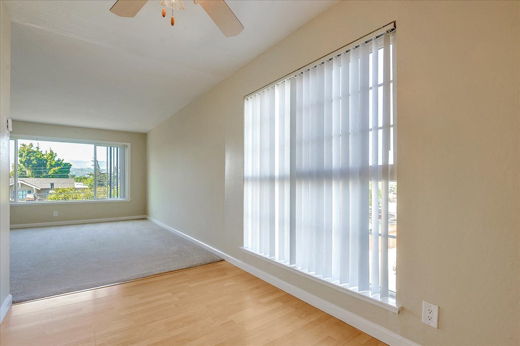 a living room with a large window and wood floors